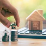 Tiny house model on stack of coins mortgage concept